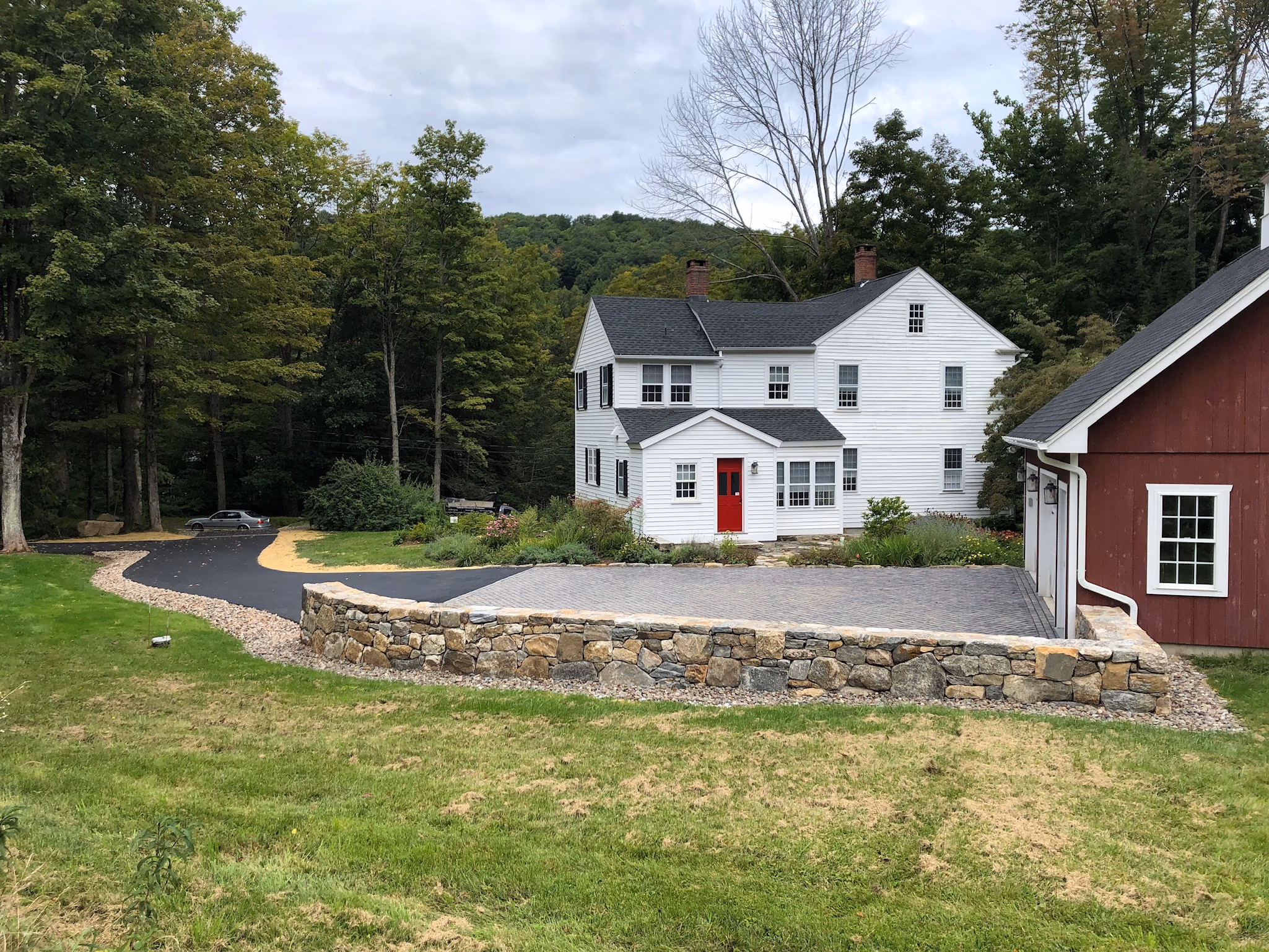 The same property with a raised paver courtyard, stone retaining wall and finished driveway.